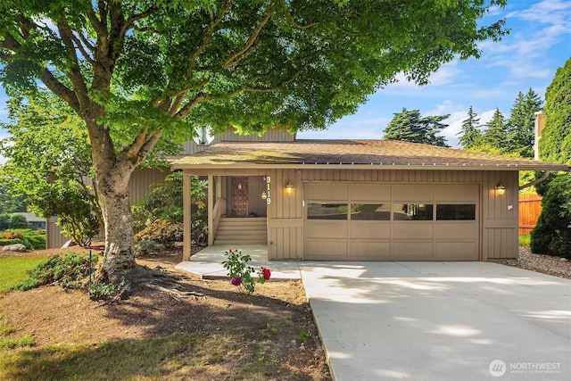 9119 185th Pl SW, Edmonds, WA 98026 - view of front of home with a garage, a shingled roof, concrete driveway, and board and batten siding