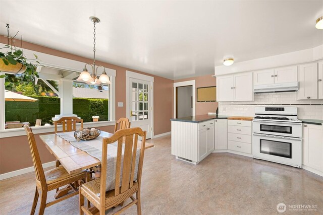 1800 Dakin St, Bellingham, WA 98229 - kitchen with range with two ovens, under cabinet range hood, a chandelier, backsplash, and a peninsula