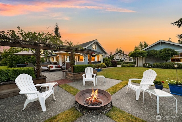 1800 Dakin St, Bellingham, WA 98229 - patio terrace at dusk with a lawn, a patio area, and an outdoor living space with a fire pit