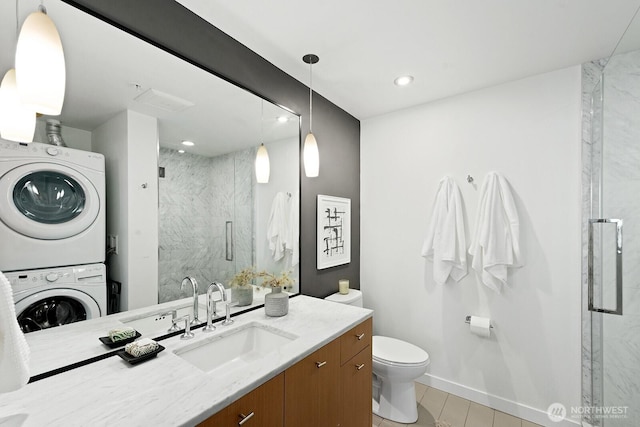 1321 Seneca St Unit 1001, Seattle, WA 98101 - bathroom with estacked washer and dryer, a marble finish shower, vanity, tile patterned floors, and recessed lighting
