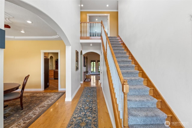 7322 NE Blue Goose Rd, Moses Lake, WA 98837 - foyer entrance featuring arched walkways, wood finished floors, crown molding, stairway, and recessed lighting