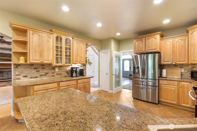 7322 NE Blue Goose Rd, Moses Lake, WA 98837 - kitchen featuring stainless steel fridge with ice dispenser, arched walkways, light brown cabinets, backsplash, and recessed lighting