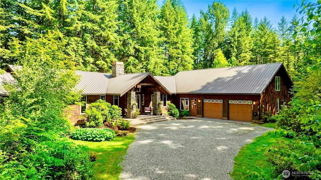 36915 NE 98th St, Carnation, WA 98014 - view of front of property featuring a chimney, a garage, driveway, and a metal roof