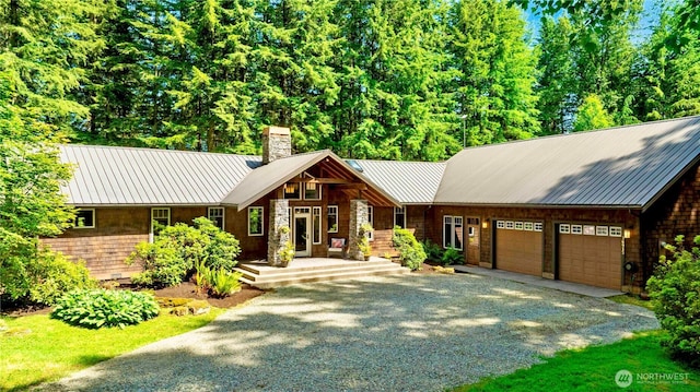 36915 NE 98th St, Carnation, WA 98014 - view of front of house featuring a chimney, driveway, an attached garage, and a metal roof