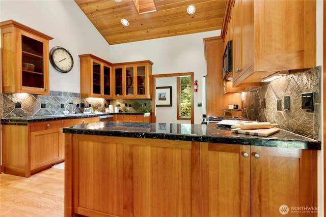 36915 NE 98th St, Carnation, WA 98014 - kitchen featuring black microwave, a peninsula, tasteful backsplash, lofted ceiling, and glass insert cabinets