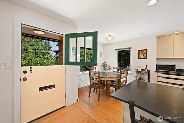 9539 49th Ave NE, Seattle, WA 98115 - kitchen featuring light wood finished floors, dark countertops, stainless steel microwave, recessed lighting, and cream cabinetry