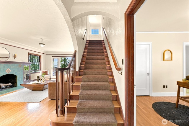 251 N Garden St, Bellingham, WA 98225 - staircase with wood finished floors, a fireplace, ornamental molding, and arched walkways