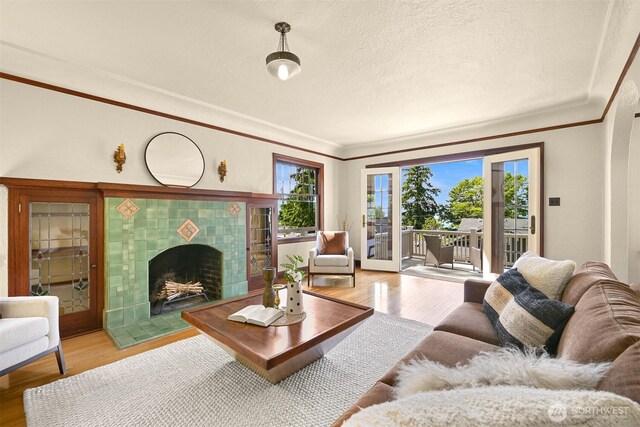 251 N Garden St, Bellingham, WA 98225 - living area with light wood-type flooring, ornamental molding, a tiled fireplace, and a textured ceiling