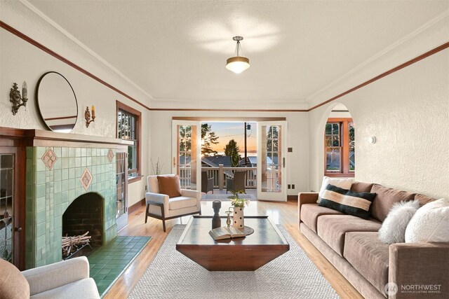 251 N Garden St, Bellingham, WA 98225 - living area with wood finished floors, arched walkways, a textured wall, a tile fireplace, and crown molding