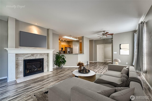 14413 Riverwalk Dr, Sumner, WA 98390 - living area with wood finished floors, ceiling fan, and a high end fireplace