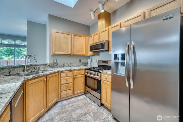 14413 Riverwalk Dr, Sumner, WA 98390 - kitchen featuring stainless steel appliances, light brown cabinets, light stone countertops, and rail lighting
