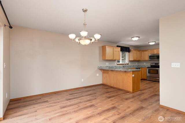 3706 54th St E, Tacoma, WA 98443 - kitchen with appliances with stainless steel finishes, light brown cabinets, light wood-type flooring, a chandelier, and a peninsula
