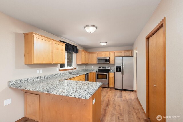 3706 54th St E, Tacoma, WA 98443 - kitchen with stainless steel appliances, light brown cabinets, a peninsula, light wood finished floors, and light stone counters