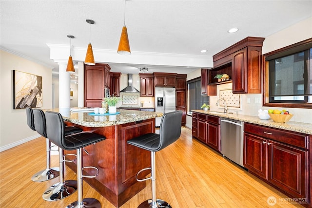 826 Lake St S, Kirkland, WA 98033 - kitchen featuring stainless steel appliances, reddish brown cabinets, wall chimney exhaust hood, ornamental molding, and a kitchen island