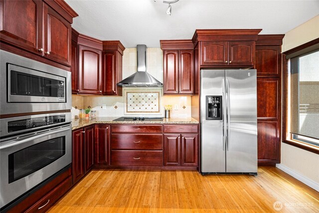 826 Lake St S, Kirkland, WA 98033 - kitchen featuring appliances with stainless steel finishes, dark brown cabinets, wall chimney exhaust hood, and light wood-style floors