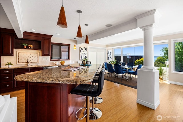 826 Lake St S, Kirkland, WA 98033 - kitchen with decorative columns, a breakfast bar, light wood-type flooring, a center island, and recessed lighting