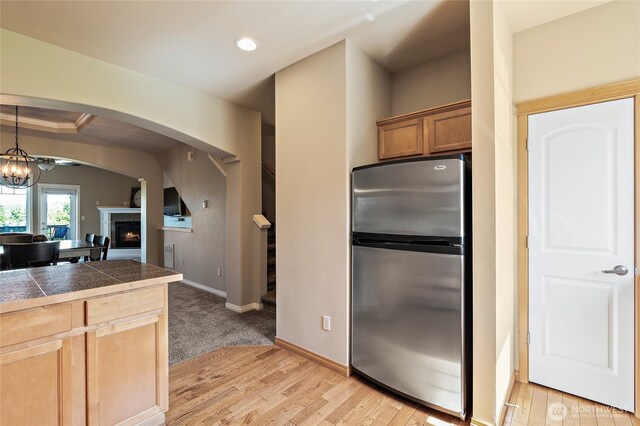 3031 Belmonte Ln, Everett, WA 98201 - kitchen featuring freestanding refrigerator, arched walkways, light wood finished floors, a lit fireplace, and recessed lighting
