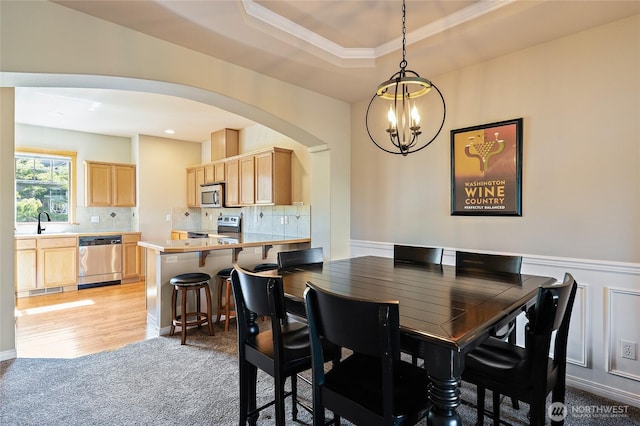 3031 Belmonte Ln, Everett, WA 98201 - dining area with a chandelier, arched walkways, light carpet, wainscoting, and a raised ceiling
