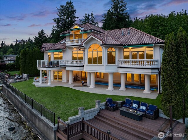 2819 E Lake Sammamish Pkwy NE, Sammamish, WA 98074 - back of house at dusk featuring a balcony, a patio area, an outdoor living space with a fire pit, stucco siding, and a wooden deck