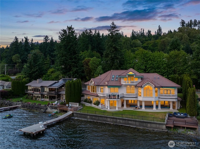 2819 E Lake Sammamish Pkwy NE, Sammamish, WA 98074 - rear view of house featuring a balcony, a water view, a patio, a tile roof, and a wooded view