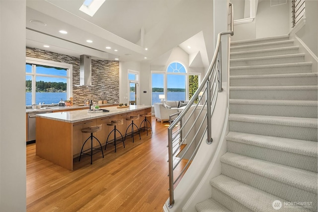 2819 E Lake Sammamish Pkwy NE, Sammamish, WA 98074 - staircase featuring recessed lighting, wood finished floors, a water view, high vaulted ceiling, and a skylight