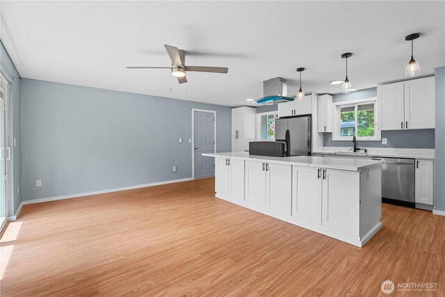 21318 125th St E, Bonney Lake, WA 98391 - kitchen featuring appliances with stainless steel finishes, light wood finished floors, ceiling fan, a center island, and light countertops