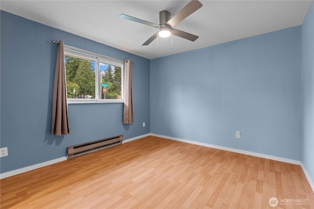 21318 125th St E, Bonney Lake, WA 98391 - empty room with baseboard heating, wood finished floors, and a ceiling fan