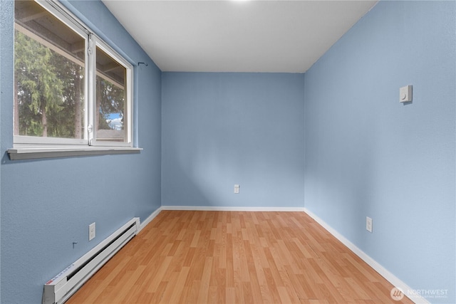 21318 125th St E, Bonney Lake, WA 98391 - empty room with a baseboard radiator and wood finished floors