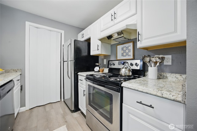 12906 8th Ave W Unit C102, Everett, WA 98204 - kitchen featuring appliances with stainless steel finishes, custom range hood, light wood finished floors, and white cabinetry