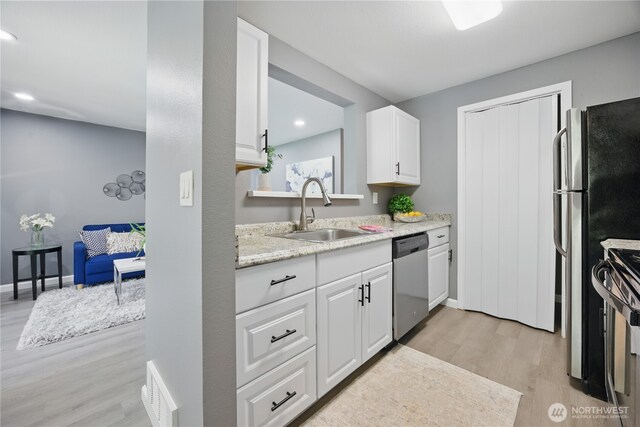12906 8th Ave W Unit C102, Everett, WA 98204 - kitchen with dishwasher, light wood-style flooring, white cabinets, stove, and recessed lighting