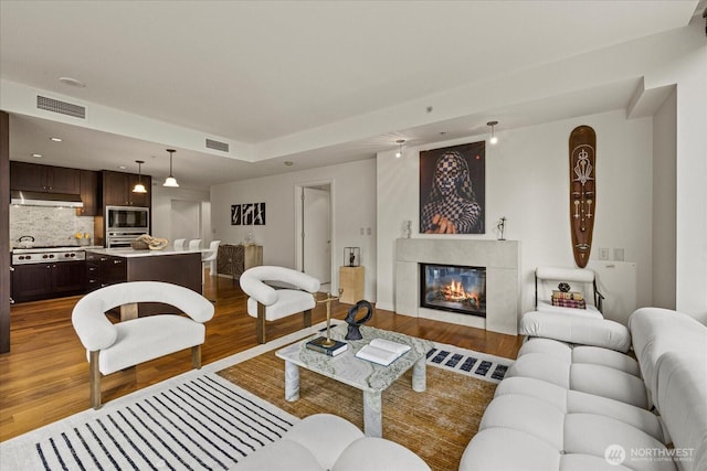 10700 NE 4th St Unit 712, Bellevue, WA 98004 - living room with wood finished floors, a tile fireplace, and recessed lighting
