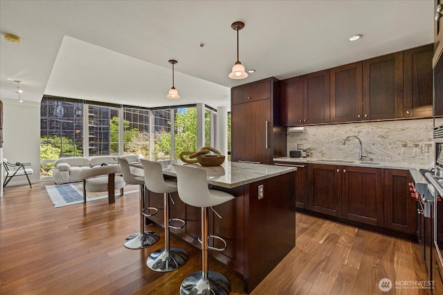 10700 NE 4th St Unit 712, Bellevue, WA 98004 - kitchen featuring tasteful backsplash, wood finished floors, healthy amount of natural light, and recessed lighting