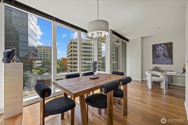 10700 NE 4th St Unit 712, Bellevue, WA 98004 - dining space with wood finished floors, floor to ceiling windows, a view of city, and a chandelier