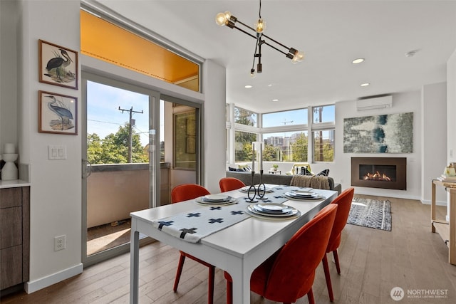 1100 14th Ave, Seattle, WA 98122 - dining area featuring a wall mounted air conditioner, light wood-style flooring, a glass covered fireplace, and recessed lighting