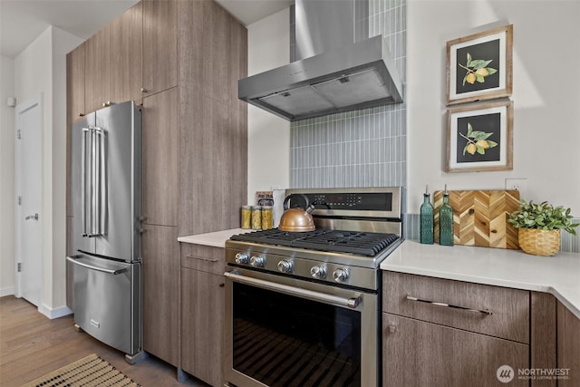 1100 14th Ave, Seattle, WA 98122 - kitchen with appliances with stainless steel finishes, wall chimney range hood, wood finished floors, light countertops, and backsplash