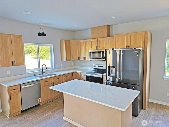 119 Davis View Dr, Centralia, WA 98531 - kitchen with appliances with stainless steel finishes, light brown cabinetry, light wood-style flooring, light stone counters, and a center island
