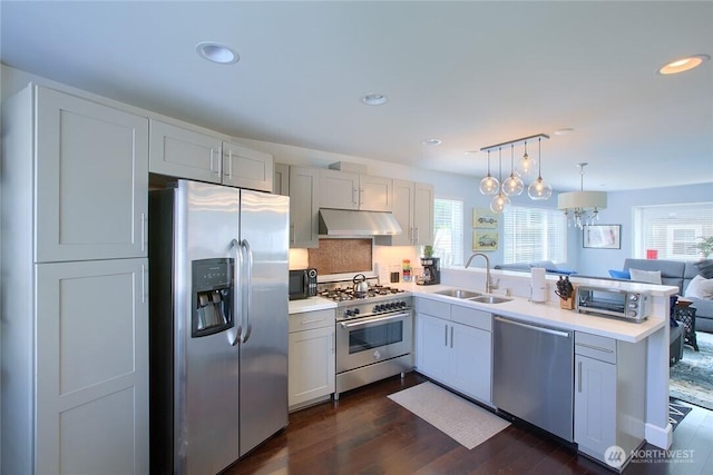 2067 Gilman Dr W, Seattle, WA 98119 - kitchen with appliances with stainless steel finishes, under cabinet range hood, a peninsula, plenty of natural light, and recessed lighting