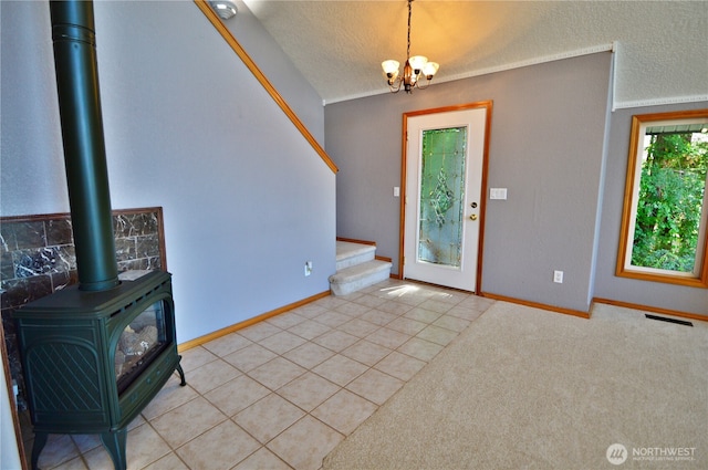 1923 SE Maple Dr, Chehalis, WA 98532 - foyer entrance featuring a wood stove, stairs, a chandelier, light tile patterned floors, and a textured ceiling