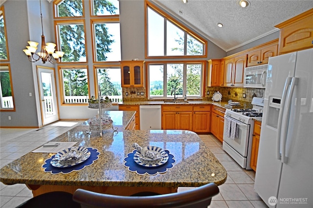 1923 SE Maple Dr, Chehalis, WA 98532 - kitchen with white appliances, light tile patterned floors, a chandelier, high vaulted ceiling, and a kitchen breakfast bar
