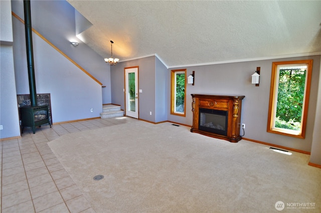 1923 SE Maple Dr, Chehalis, WA 98532 - unfurnished living room with stairs, tile patterned floors, a textured ceiling, a chandelier, and a glass covered fireplace