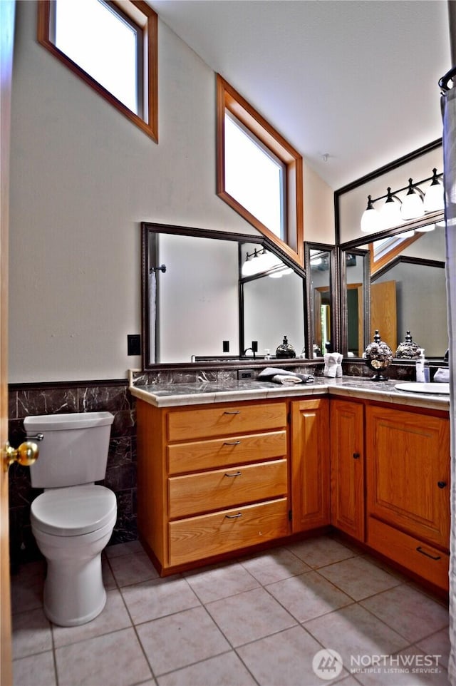 1923 SE Maple Dr, Chehalis, WA 98532 - bathroom featuring tile patterned floors, double vanity, wainscoting, and tile walls