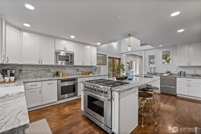 8213 S Fawcett Ave, Tacoma, WA 98408 - kitchen with stainless steel appliances, tasteful backsplash, white cabinetry, light stone countertops, and recessed lighting