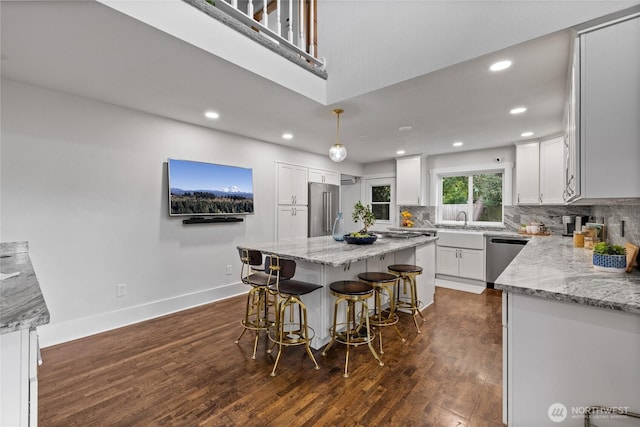 8213 S Fawcett Ave, Tacoma, WA 98408 - kitchen featuring stainless steel appliances, recessed lighting, dark wood-type flooring, a kitchen bar, and a kitchen island