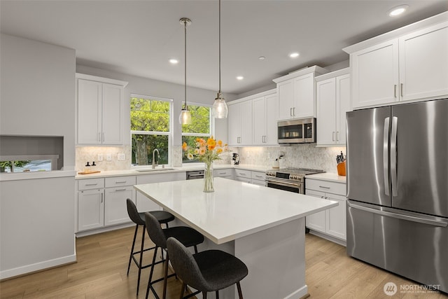 12124 NE 194th Ct Unit C, Bothell, WA 98011 - kitchen with appliances with stainless steel finishes, light wood-type flooring, backsplash, recessed lighting, and a kitchen breakfast bar