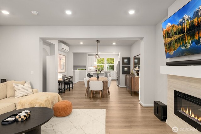 12124 NE 194th Ct Unit C, Bothell, WA 98011 - living room featuring light wood-style floors, an AC wall unit, a tiled fireplace, and recessed lighting