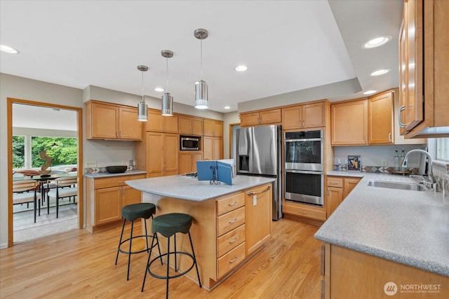 6520 NE 60th St, Seattle, WA 98115 - kitchen featuring stainless steel appliances, a center island, a breakfast bar, recessed lighting, and light wood-style flooring