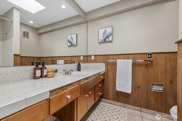 6520 NE 60th St, Seattle, WA 98115 - bathroom with a skylight, vanity, a wainscoted wall, tile patterned floors, and a shower