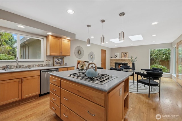 6520 NE 60th St, Seattle, WA 98115 - kitchen with appliances with stainless steel finishes, a skylight, a brick fireplace, healthy amount of natural light, and recessed lighting