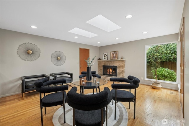6520 NE 60th St, Seattle, WA 98115 - living area with a skylight, a brick fireplace, light wood-style flooring, and recessed lighting