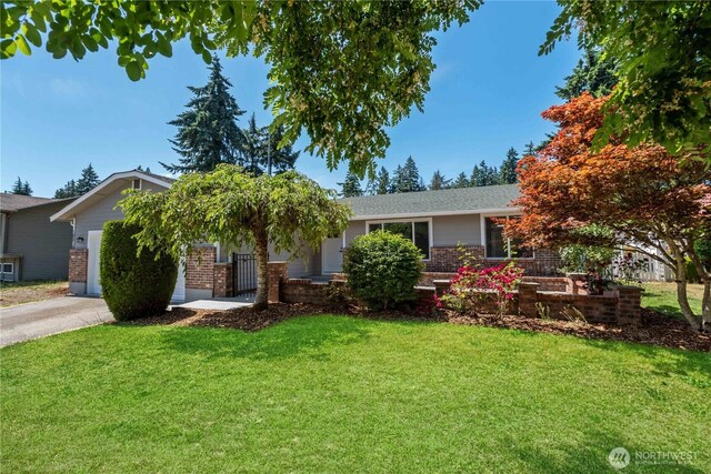 10218 63rd Avenue Ct E, Puyallup, WA 98373 - view of front facade featuring a front lawn, an attached garage, brick siding, and concrete driveway